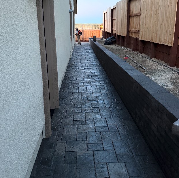Paver walkway alongside a home and retaining wall